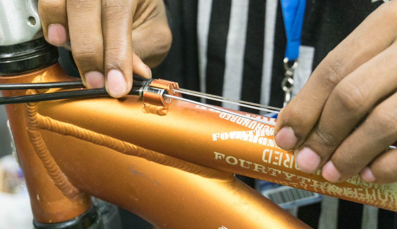 Hands on bicycle cables by top tube