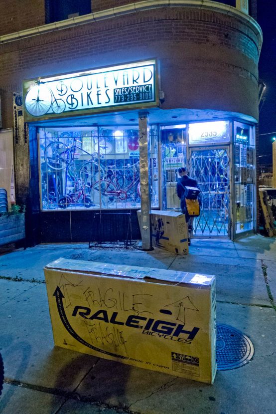 Two bike boxes on the sidewalk in the early morning outside a bike shop in Chicago