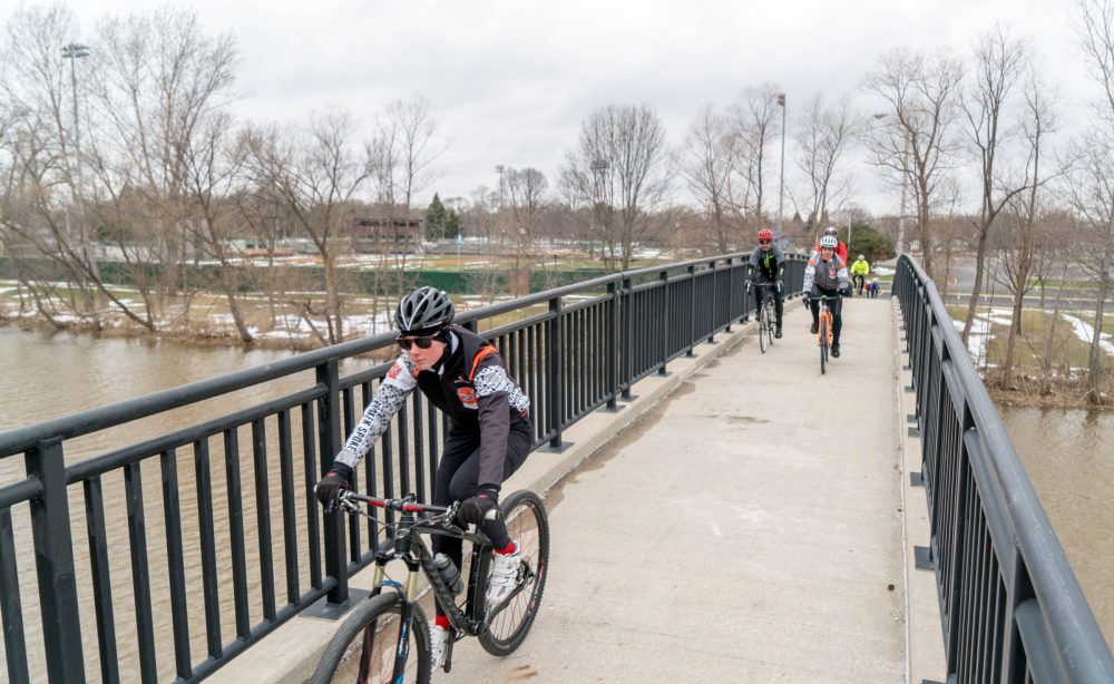 cyclists riding over bike bridge