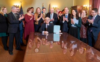 Governor Evers surrounded by clapping people after signing e-bike legislation