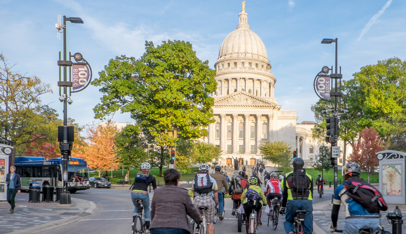 A group of people riding bicycles in front of the Wisconsin State Capital Building