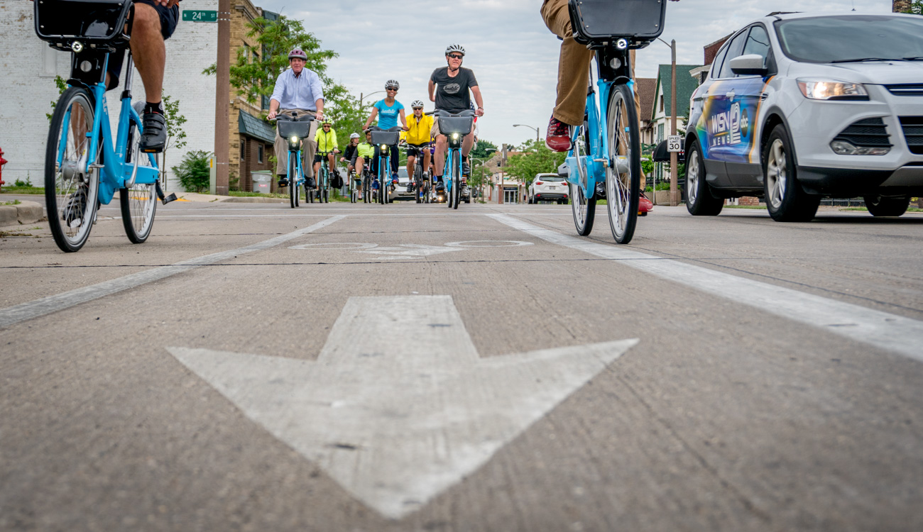 Low angle photo in bike lane of people riding toward the camera