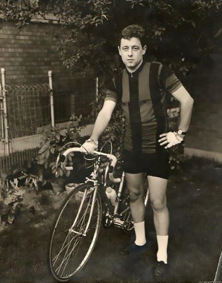 Black and white vintage photo of a young Otto Wenz standing next to a bicycle