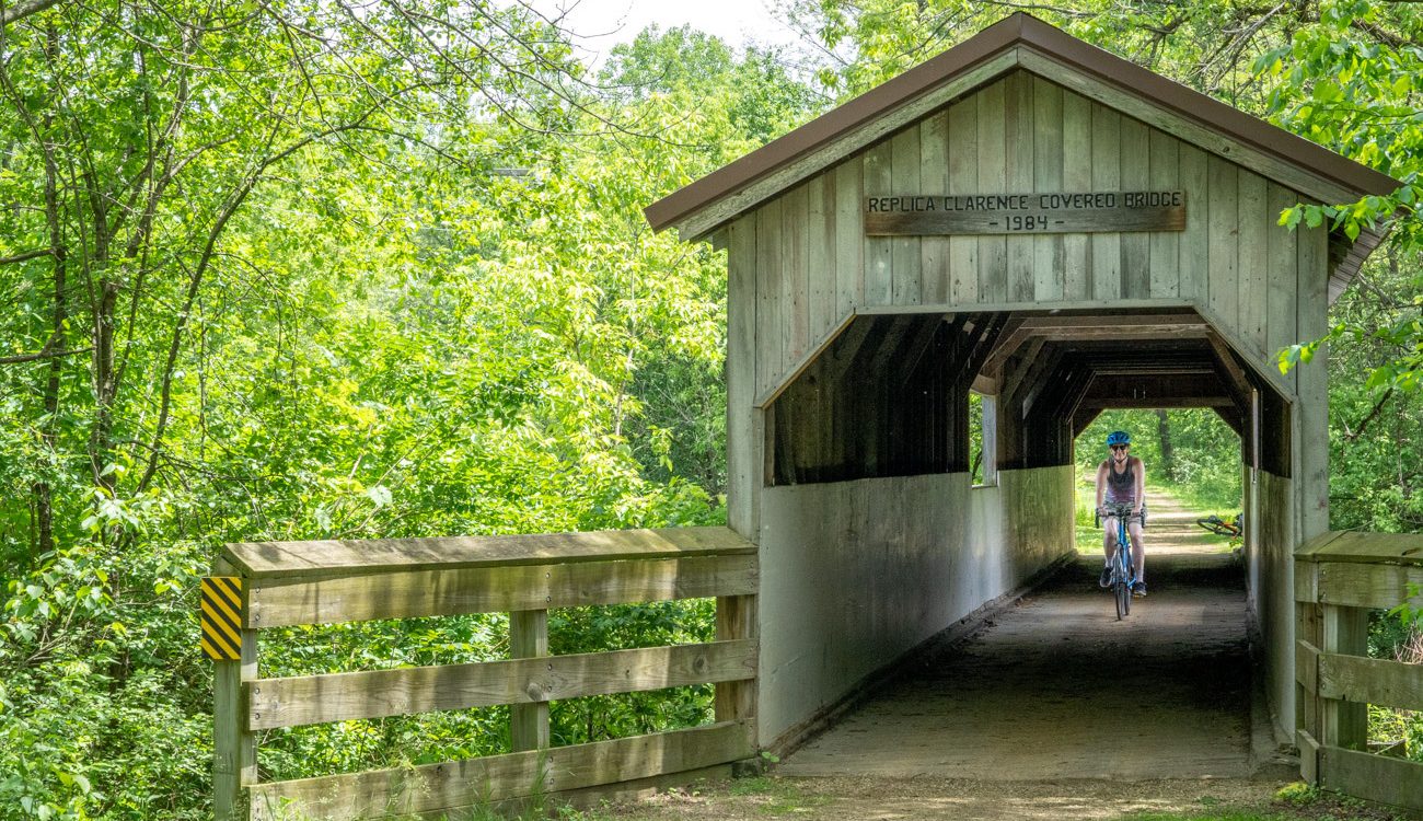 A woman rides a bicycle through the Covered Bridge on the Sugar River State Trail north of Brodhead