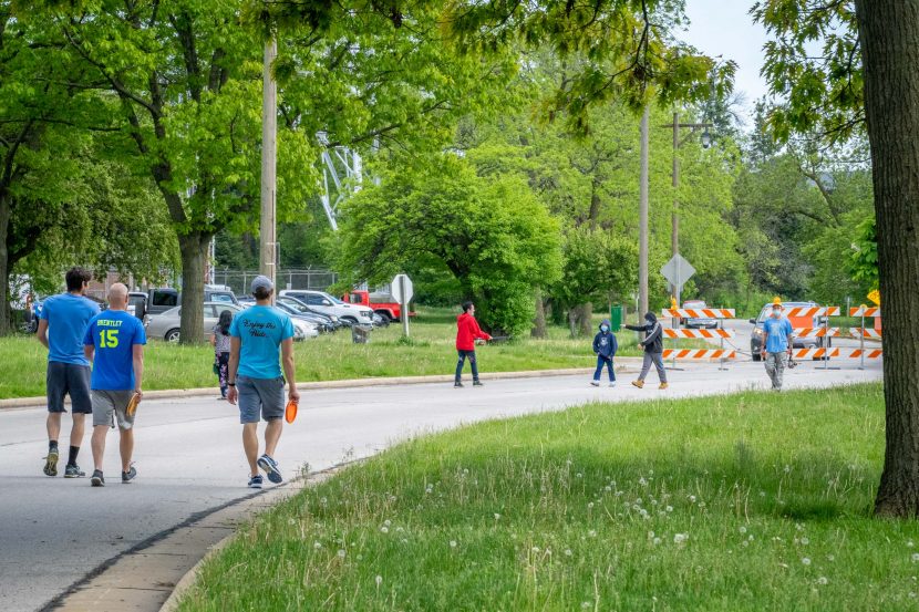 People walk on Estabrook Parkway in Milwaukee County's Estabrook Park