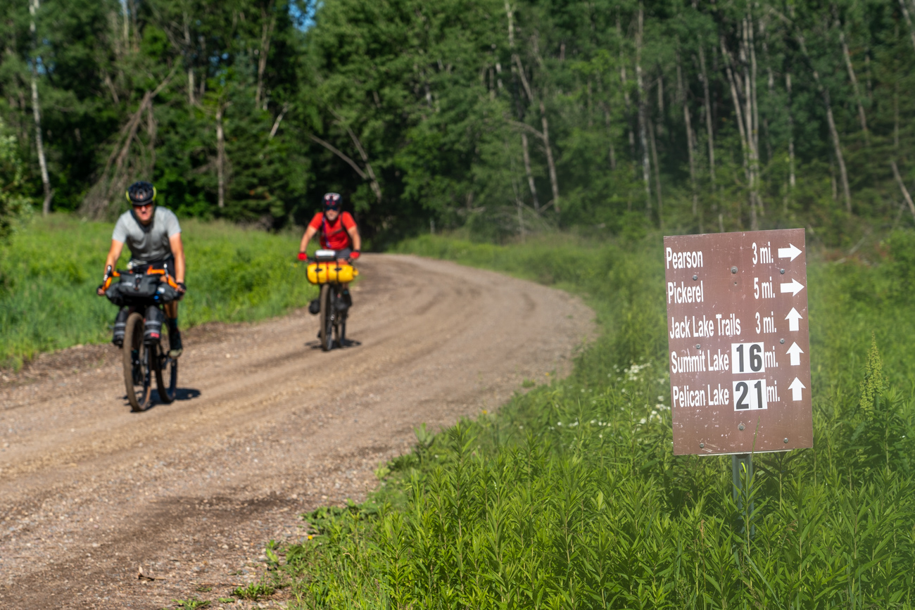 Distance signs on gravel road.