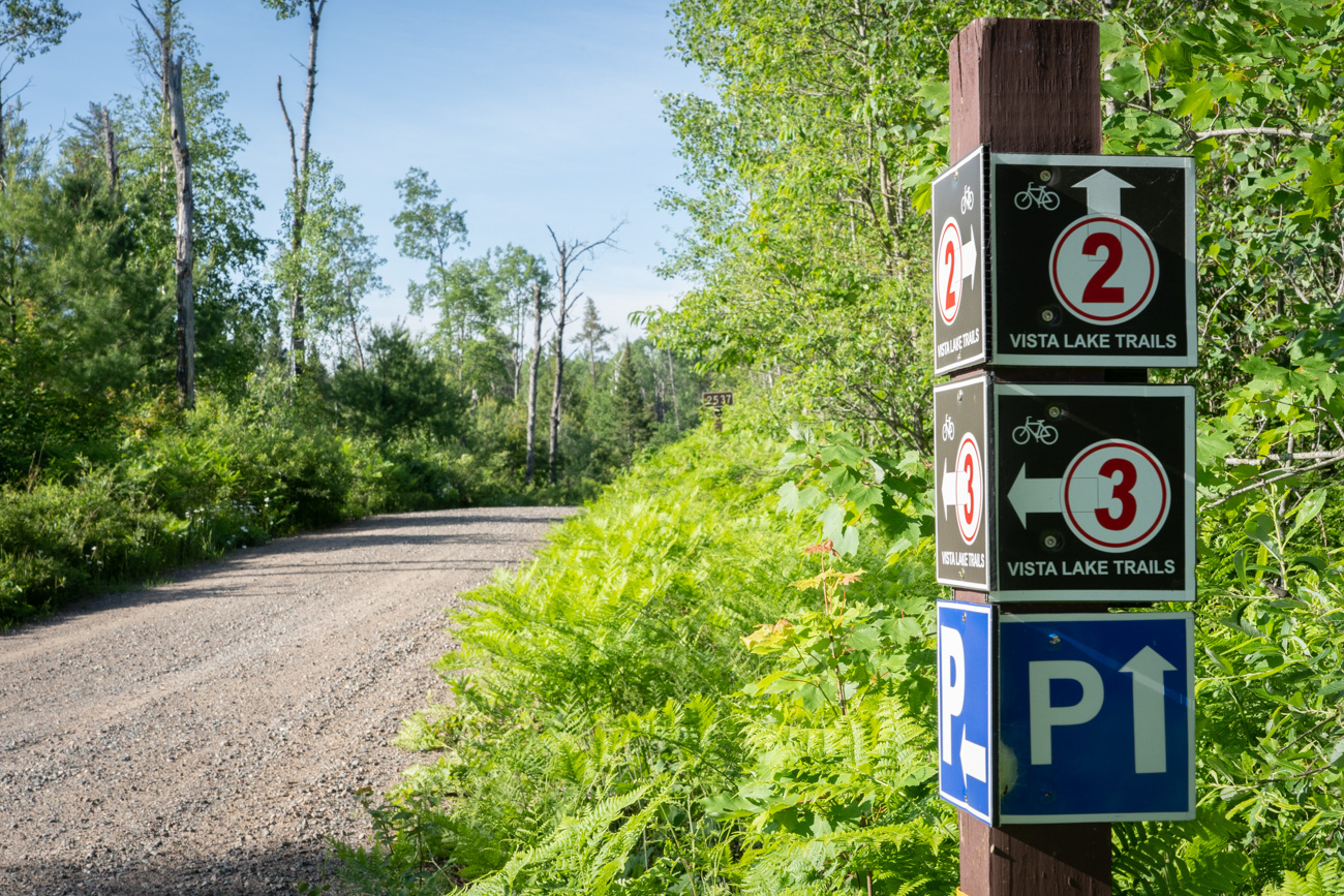 bicycle wayfinding signs next to gravel road