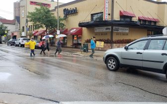 people cross street while car waits