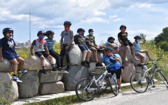 kids sit on rocks to rest after a bike ride