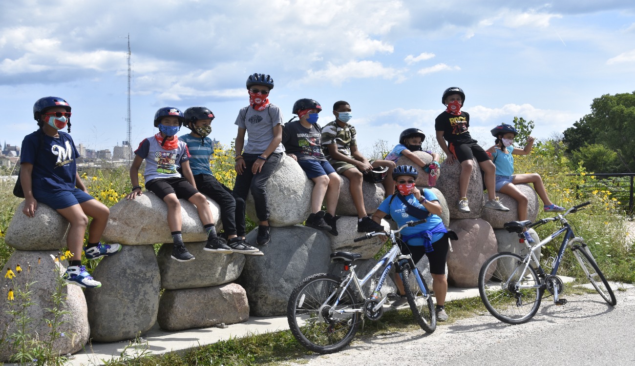 kids sit on rocks to rest after a bike ride