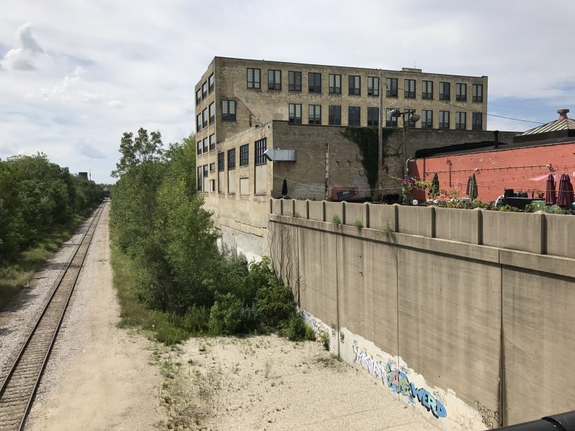 An empty railroad passing through an urban environment.