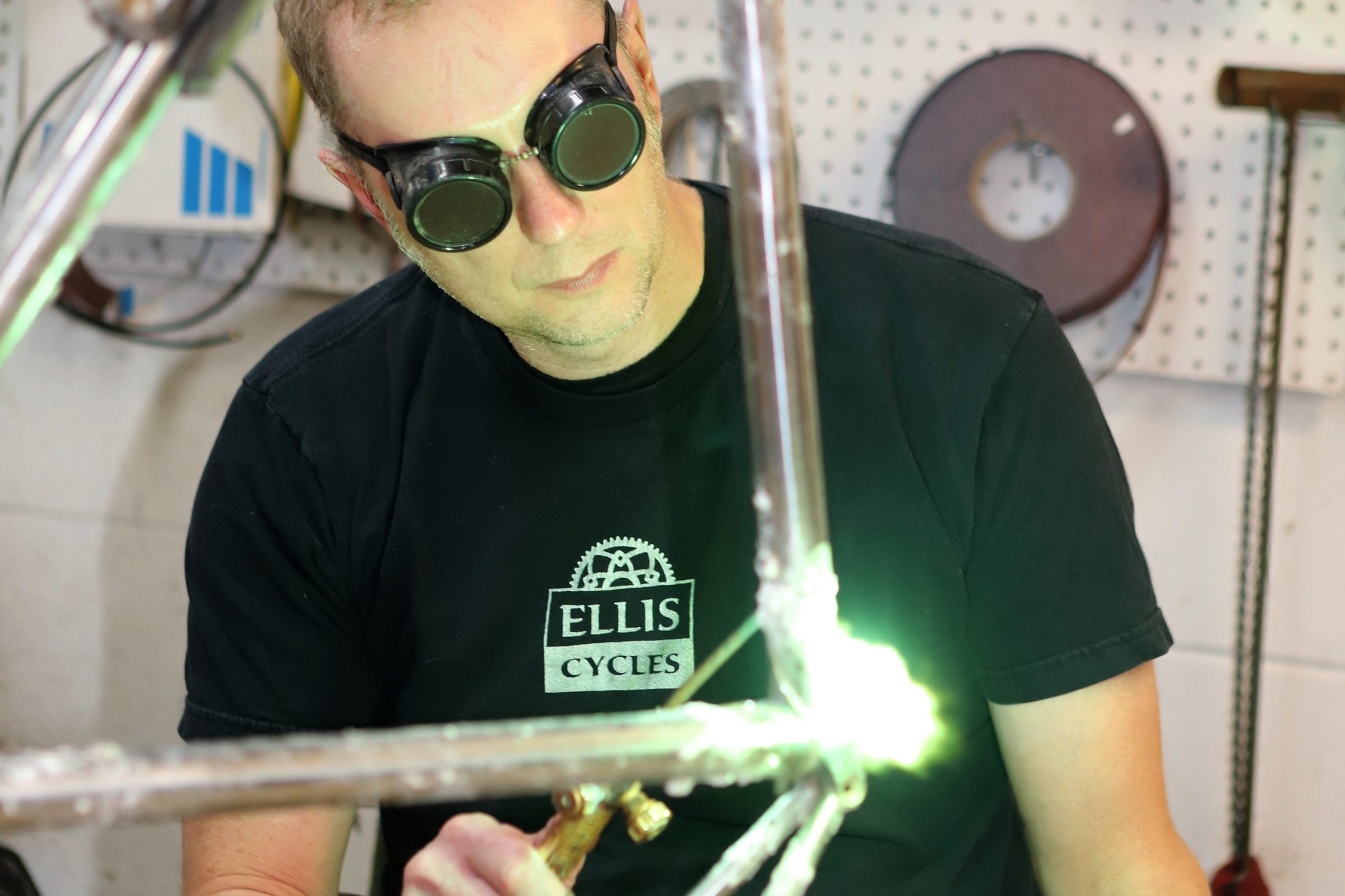 Dave Wages, wearing goggles, welds the top tube of the Schwinn Paramount
