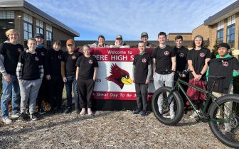 Student bike club members and faculty standing outside school