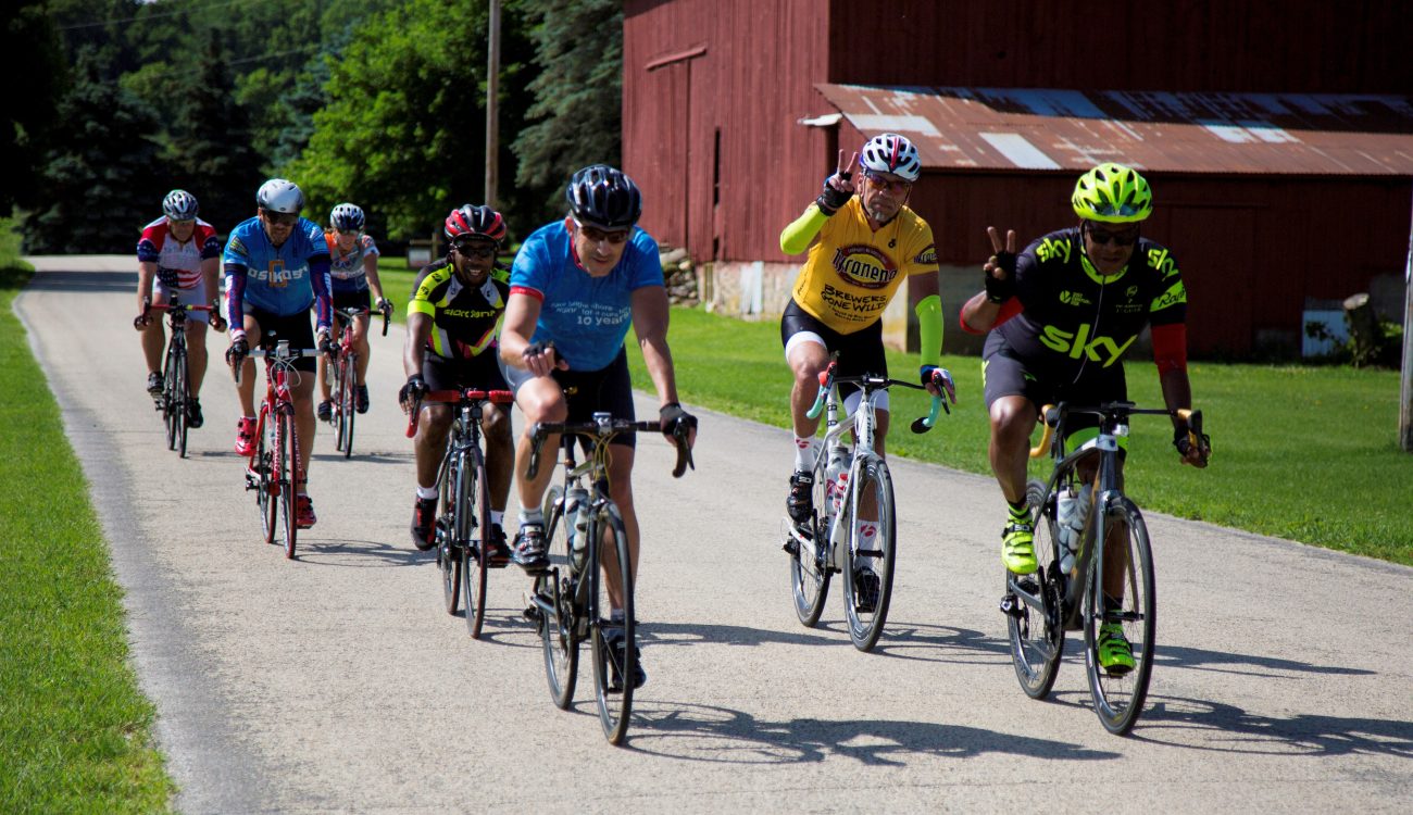 Group of riders on quiet road near barn
