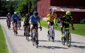 Group of riders on quiet road near barn