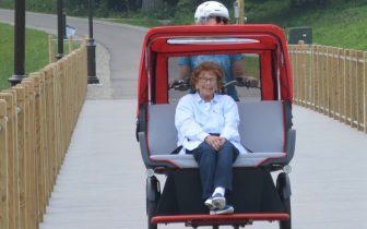 Cycling Without Age pilot and passenger on path