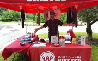 Board member and volunteer Nick welcomes visitors to the Bike Fed booth at Tour of America's Dairyland race in Wauwatosa June 2021