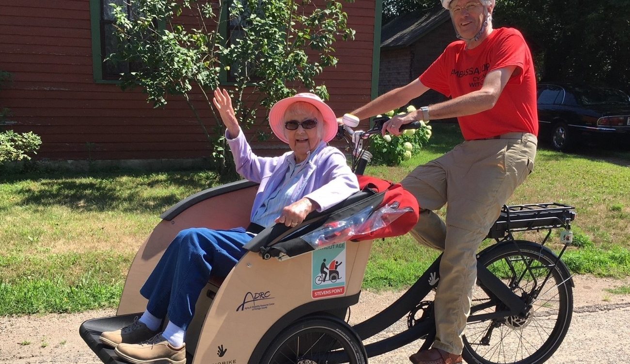 volunteer pilot pedaling Betty in a trishaw