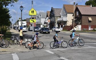 children walk bikes across street in a crosswalk