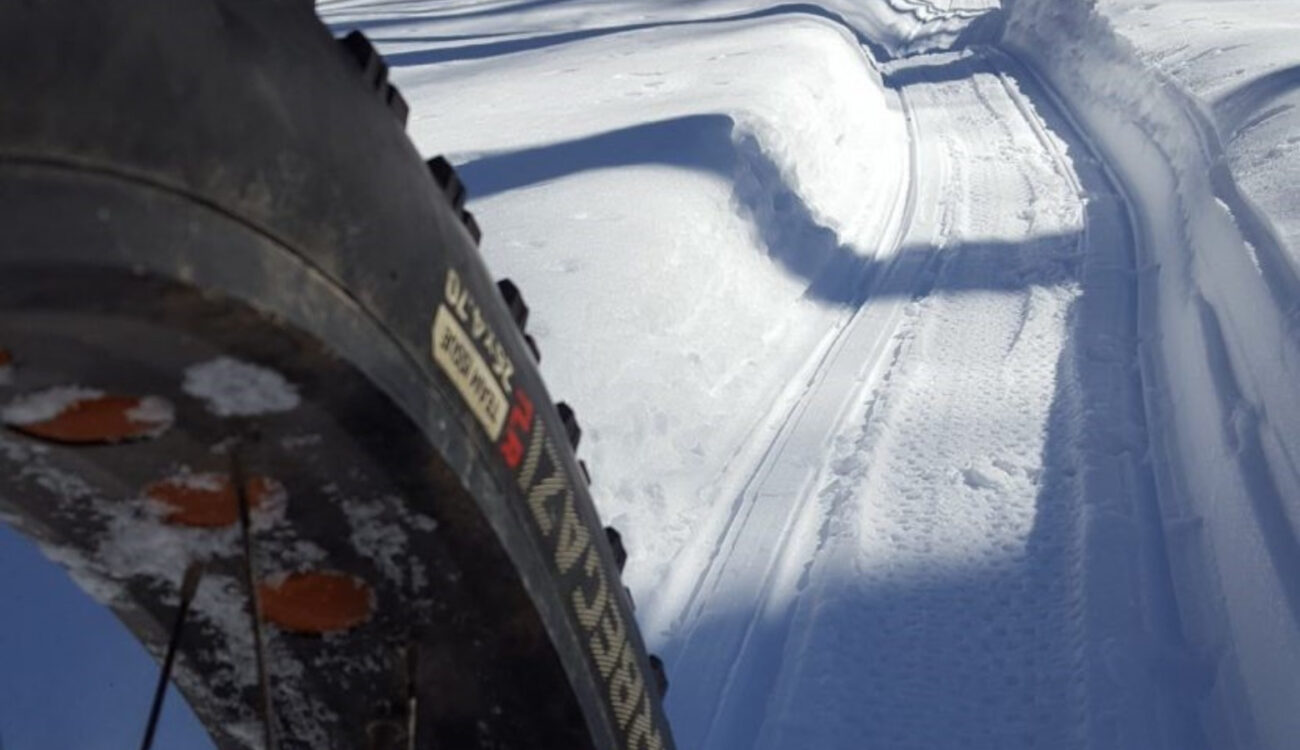 image of tire riding on groom snowy path