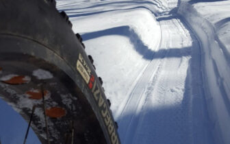 image of tire riding on groom snowy path