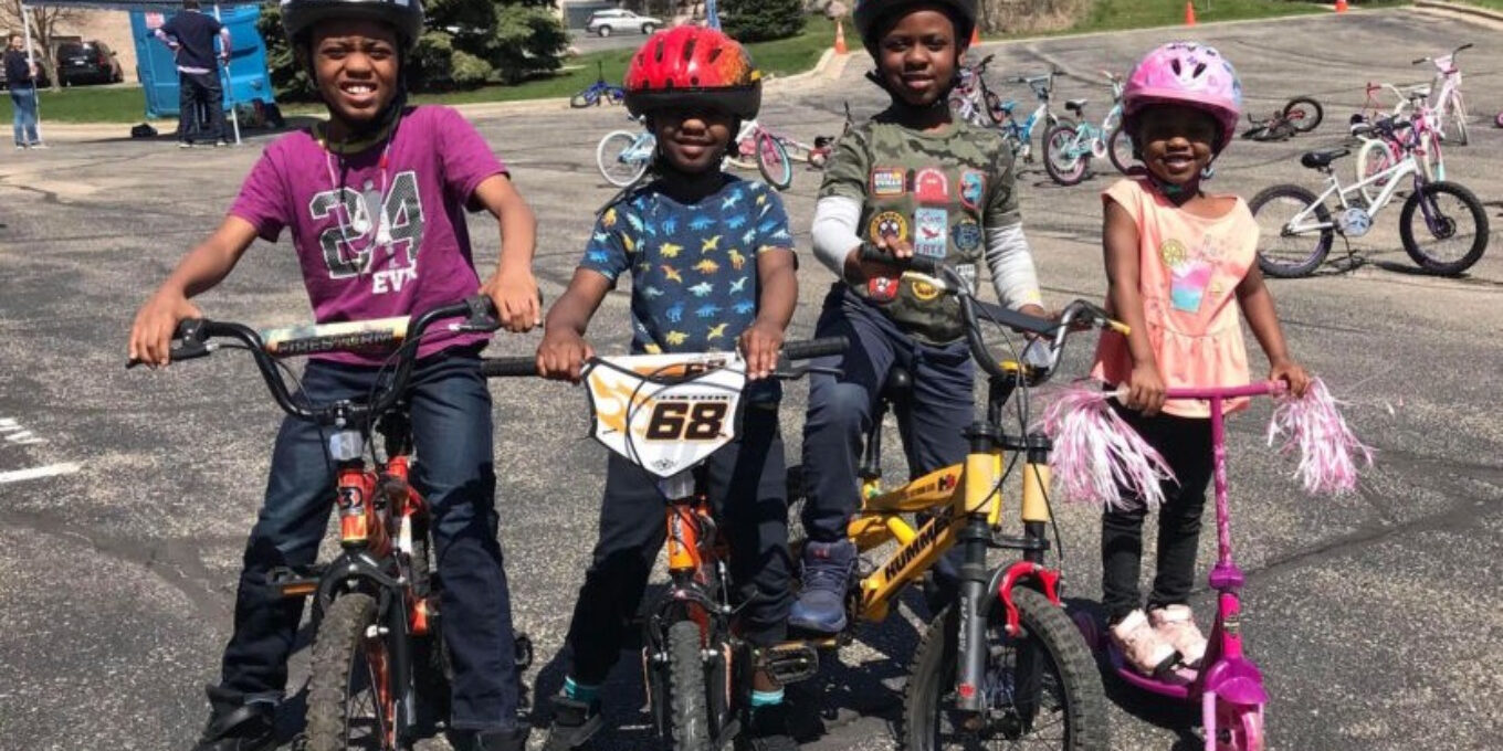 4 youth riders standing over bikes