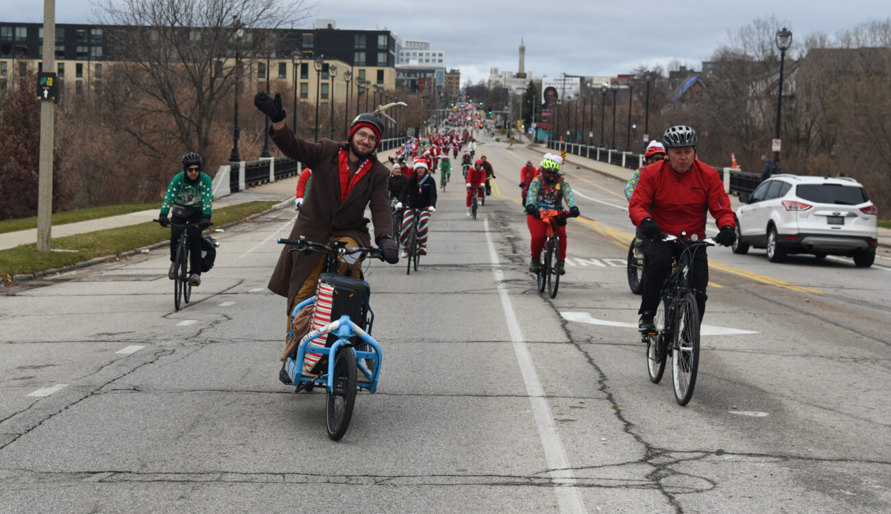 riders dressed in holiday costumes wave and ride down North Ave