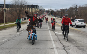 riders dressed in holiday costumes wave and ride down North Ave