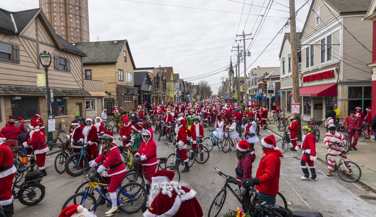 hundreds of bike riders in holiday costumes fill a city street