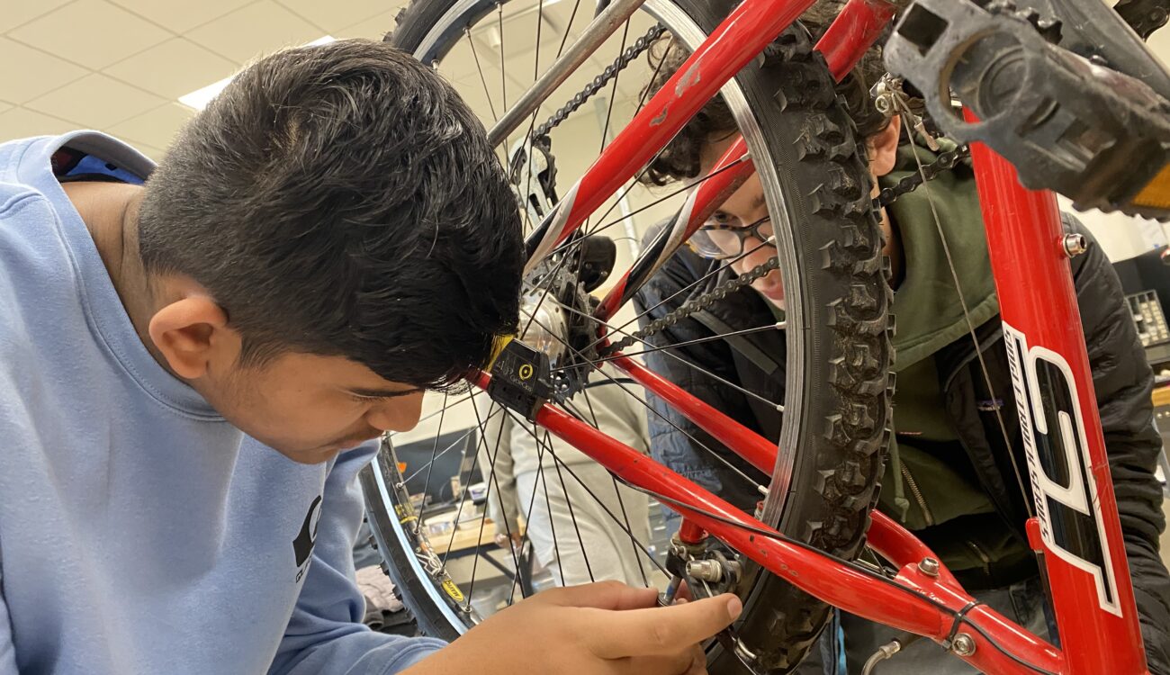 Two students work on a bike
