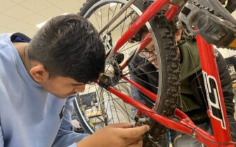Two students work on a bike