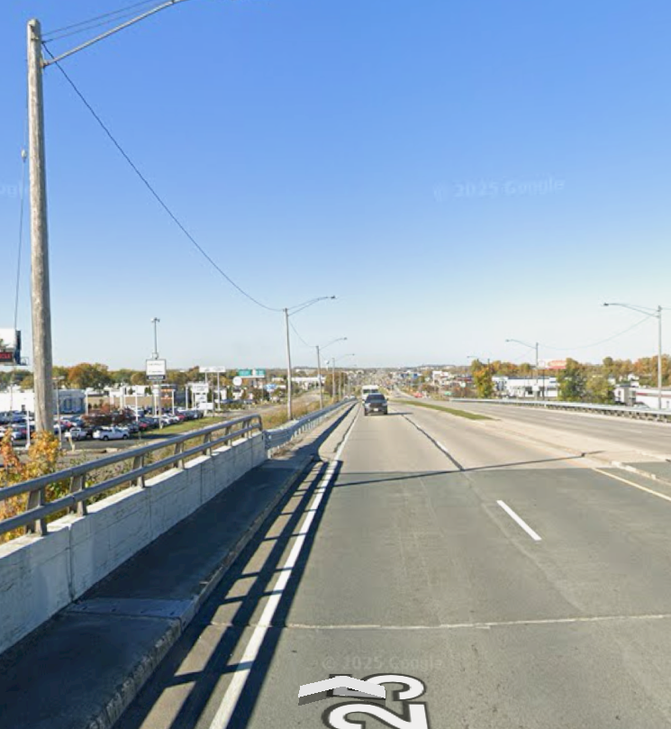 Street view of a wide road with one car