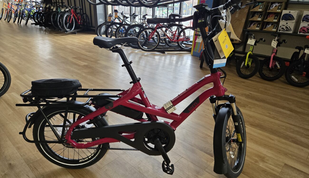 a purple electric bicycle with 20" wheels resting on a bike shop show room floor